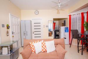 a living room with a couch and a clock on the wall at Ocho Rios Ocean View Sleeps1-2 in Ocho Rios