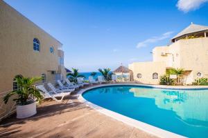 a swimming pool with lounge chairs next to a building at Ocho Rios Ocean View Sleeps1-2 in Ocho Rios