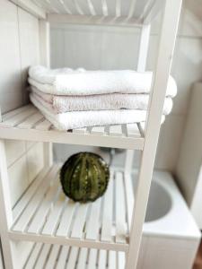 a white closet with towels and a melon on a shelf at Stilvolle Wohnung im Allgäu in Kempten