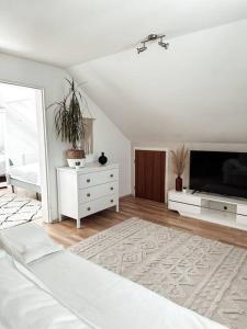 a white bedroom with a bed and a tv at Stilvolle Wohnung im Allgäu in Kempten