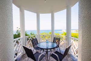 - une terrasse couverte avec une table et des chaises et l'océan dans l'établissement Ocho Rios Ocean View Sleeps1-2, à Ocho Rios