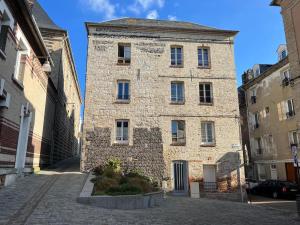 un grand bâtiment en briques dans une cour d'une ville dans l'établissement Duplex Beauregard - calme & proche de la plage, à Dieppe