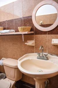 a bathroom with a sink and a toilet and a mirror at Departamento cerca del Ferry y del Centro de Holbox in Holbox Island