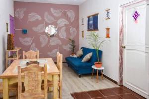 a dining room with a table and a blue couch at Departamento cerca del Ferry y del Centro de Holbox in Holbox Island