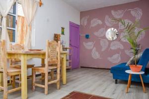 a dining room with a table and a purple wall at Departamento cerca del Ferry y del Centro de Holbox in Holbox Island +13 photos