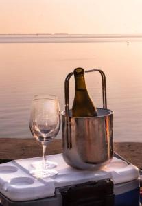 Coral Cottage pool/firepit a 2 bed 2 bth sleeps 6 في بالم هاربور: زجاجة من النبيذ في دلو بجوار الزجاج