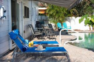 een patio met een tafel en stoelen naast een zwembad bij Coral Cottage pool/firepit a 2 bed 2 bth sleeps 6 in Palm Harbor