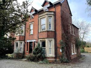 ein altes Backsteinhaus mit weißen Fenstern auf einer Straße in der Unterkunft The Burley at Scalford House in Melton Mowbray