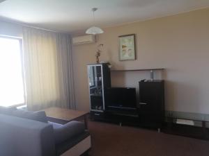 a living room with a couch and a tv at Villa Vega in Sozopol