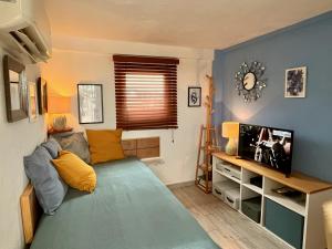 sala de estar con sofá y TV en "Le Petit Bonheur" Cozy studio near beach, en Puerto Vallarta