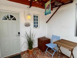 un porche con una mesa de madera y una puerta en "Le Petit Bonheur" Cozy studio near beach, en Puerto Vallarta