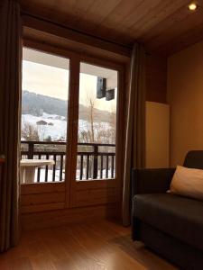 a living room with a large sliding glass door with a view at Studio face aux pistes in Praz-sur-Arly