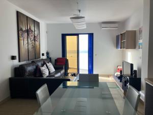 a living room with a glass table and a couch at Sea&Harbour Puerto del Carmen in Puerto del Carmen +5 photos