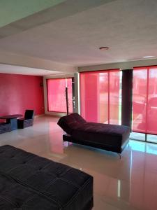 ein großes Wohnzimmer mit Sofa und roten Wänden in der Unterkunft Casa Chignahuapan fraccionamiento Green City in Chignahuapan