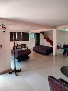 ein Wohnzimmer mit einem Sofa und einer Treppe in der Unterkunft Casa Chignahuapan fraccionamiento Green City in Chignahuapan