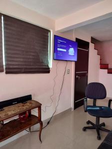 Zimmer mit einem TV, 2 Stühlen und einem Tisch in der Unterkunft Casa Chignahuapan fraccionamiento Green City in Chignahuapan