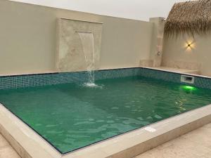 una piscina con una fuente en un edificio en Lubanya Chalet, en Salalah