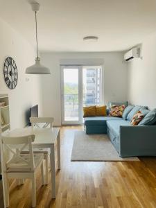 a living room with a blue couch and a table at Apartment Park in Novi Sad