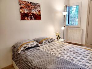 a bedroom with a bed and a painting on the wall at Superbe appartement 3p, parking gratuit proche Paris in Châtenay-Malabry