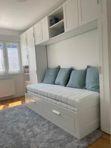 a white couch with blue pillows in a room at Apartment Park in Novi Sad +11 photos