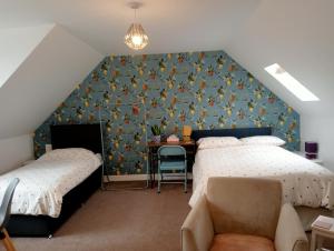 a attic bedroom with two beds and a desk at Hill View Studio in Hawick