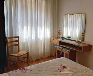 ein Schlafzimmer mit Schreibtisch mit Spiegel und Bett in der Unterkunft DaRenato in Santo Stefano di Cadore