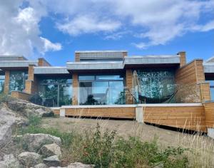 a house on a hill with glass at Nybygget hus i Svaneke tæt på klipper, skov og hav in Svaneke