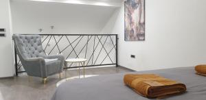 バニャ・ルカにあるR-RESIDENCY DELUXE Blのベッドルーム1室(椅子、毛布付きのベッド1台付)