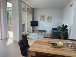 a living room with a table and a couch at Nybygget hus i Svaneke tæt på klipper, skov og hav in Svaneke