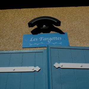 a sign on top of a blue garage door at Nid douillet - LES FARGETTES - superbe vue - charmante petite maison avec jardin - 2 pièces à Privas in Privas