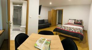 a bedroom with a bed and a table and chairs at Mountain View Guest Rooms in Jedlina-Zdrój +12 photos