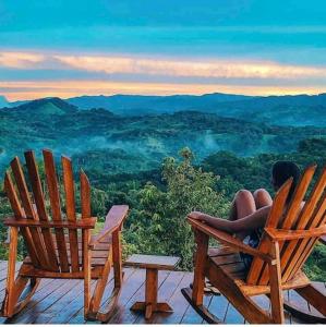 a woman sitting in chairs on a deck looking at the mountains at Luxury Villa Caoba- Private, Serene, Amazing Views in San Mateo