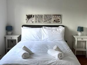 a white bed with towels on top of it at Chaplin House in Sileby