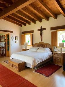 sypialnia z łóżkiem i krzyżem na ścianie w obiekcie Valle de Bravo Casa Los Ailes I w mieście Valle de Bravo