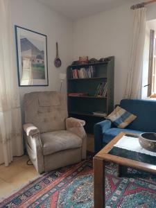 uma sala de estar com um sofá, uma cadeira e uma mesa em Casa "Berto e Costantina" CIPAT 22253 em Tregiovo