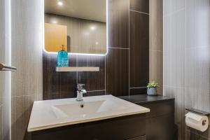 a bathroom with a sink and a mirror at Brimmond Homes - nr to Univ, Hospitals, o2 Apollo, PLAB & 7 mins to City Centre - Stylish, Modern & Secure 2 Bed, 2 Bath Apt with Allocated Free Parking in Manchester