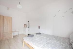 a white bedroom with a bed and a desk at Central Apartments Gdansk&Kotw21 in Gdańsk
