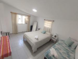 ein Schlafzimmer mit einem Bett und einer Couch in der Unterkunft La Casa de Belén in Villa General Belgrano