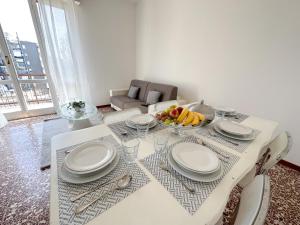 una mesa de comedor blanca con un bol de fruta. en Giulia Apartment en Cassina deʼ Pecchi