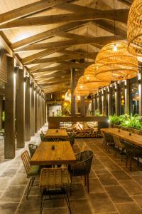 un restaurante con mesas de madera, sillas y lámparas de araña en El Lugar del que te hable Hotel Boutique en Valle de Bravo