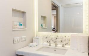 a white bathroom with a sink and a mirror at Hampton Inn By Hilton Tijuana in Tijuana
