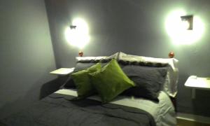 um quarto com uma cama com duas luzes na parede em Hostal El Farolito em Humahuaca