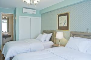 2 łóżka w pokoju z niebieskimi ścianami w obiekcie Arvo Hotel Boutique w mieście Trujillo