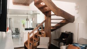 a wooden staircase in a living room next to a kitchen at King Bed & Fenced Yard - Floyd's Freedom- in Alexandria