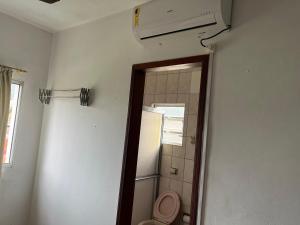 a bathroom with a toilet and a air conditioner at APTOS FAMILIA com AR CONDICIONADO UBATUBA Praia Pereque Acu in Ubatuba