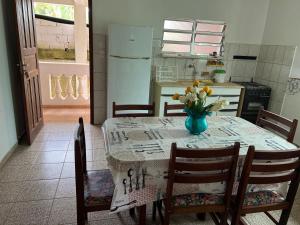 a kitchen with a table with a vase of flowers on it at APTOS FAMILIA com AR CONDICIONADO UBATUBA Praia Pereque Acu in Ubatuba