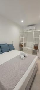 a bedroom with a large white bed with blue pillows at Sabbia Suites Varadero in Puerto del Carmen +5 photos