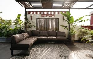 a brown leather couch in a room with plants at Lofterra in Kozhikode