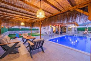 a villa with a pool and a table and chairs at Villa Vareste & Villa Taş Mahal in Fethiye