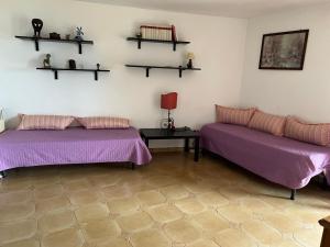a room with two beds and a table and shelves at Villa Isa in Rio Marina